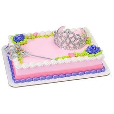 a pink cake with a tiara on top and purple flowers around the edges is shown