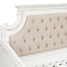 a white bed frame with buttons on the headboard and foot board is upholstered