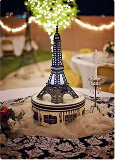 the eiffel tower is on display in front of a table with flowers and candles