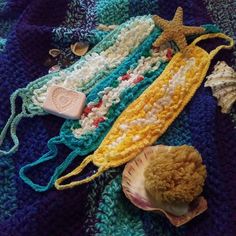 a crocheted blanket with shells and other items on it, including a starfish