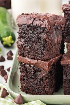 chocolate cupcakes stacked on top of each other in front of a glass of milk