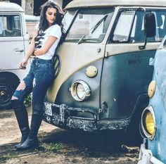 a woman standing next to an old vw bus