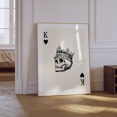 a playing card with a skull wearing a crown on it in front of a window