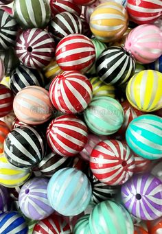 many different colored striped balls are stacked on top of each other