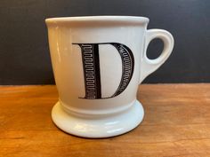 a white coffee cup sitting on top of a wooden table