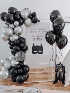 black and silver balloons are in the shape of a batman