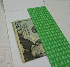 a green and white dollar bill sitting on top of a piece of paper