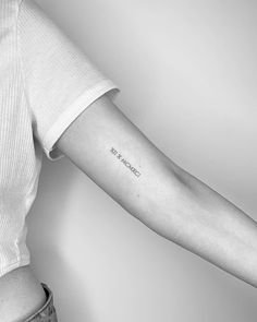 a woman's arm with the word love on it, and an arrow tattoo