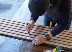 two people are working on a bench with some screwdrivers and pliers in their hands