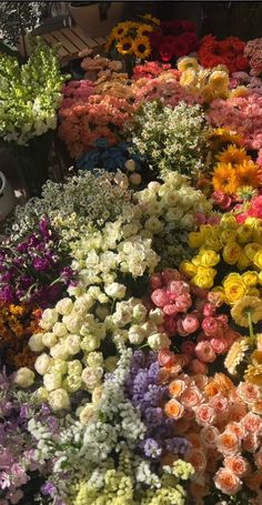 many different colored flowers are on display for sale