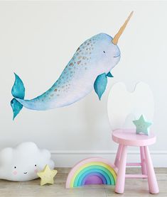 a wall decal of a narwhale with a rainbow tail and stars