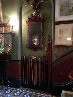 an old fashioned bathroom with green walls and red trimmings, decorated with antlers on the wall