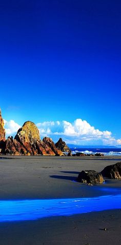 the beach is covered in blue water and rocks