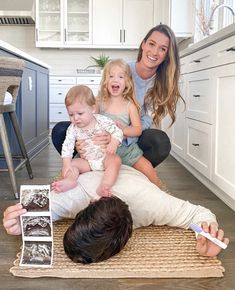 a woman and two children sitting on the floor