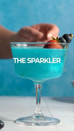 the sparkler cocktail is garnished with berries