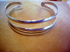 This is a comfortable and stable cuff. The bezel shown is 18mm.  (there is a second bracelet in one picture with a larger cup- it is in another listing.  This is for the one shown as smooth 4.5mm bands. The photo is for comparison of the bands really.)  I am happy to hammer pattern it for you.  it does give them more spring and tensile strength. All metal is solid .925 sterling silver. Almost all I use is recycled/reclaimed right here in Texas by a proud Cajun (of German descent)  who it serious Adjustable Silver Cuff Bracelet, Adjustable Silver Cuff Bracelet With Polished Finish, Double Cuff, Stacker Rings, Wide Bands, Solid 925 Sterling Silver, Prong Setting, Cuff Bracelet, Cuff Bracelets