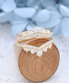 two gold rings sitting on top of a piece of wood