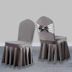 two gray chairs with silver covers and a bow on the back one chair has a white ruffle skirt