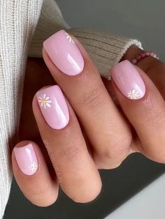 Short, rounded nails coated in a pastel pink polish, each accented with a single white daisy with a yellow center near the base, offering a minimalist and feminine nail aesthetic. Floral Spring Nails Short, Floral Pastel Nails, Daisy Short Nails, Daisy On Nails, Pink And White Flower Nails, Short Rounded Square Nails, Short Daisy Nails, White Daisy Nails