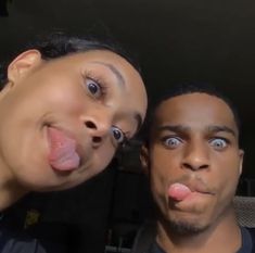 two people sticking their tongue out in front of the camera with one person making a face