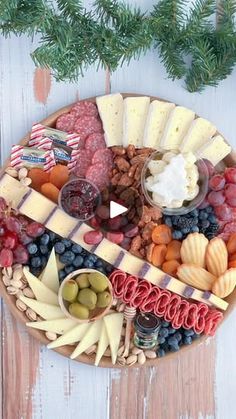 a platter filled with cheese, fruit and crackers