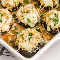 stuffed mushrooms with cheese and parsley in a white casserole dish