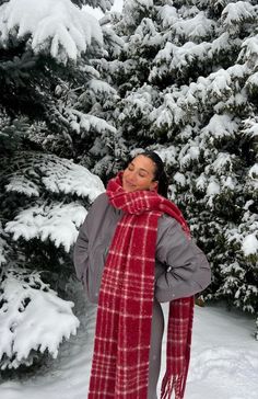 a woman standing in front of snow covered trees