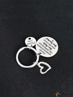 two key chains with words on them sitting next to each other in front of a black background