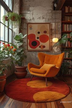 an orange chair sitting on top of a red rug in front of a book shelf