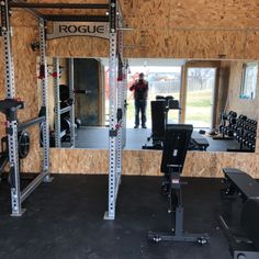 a man standing in front of a mirror next to a gym equipment set up inside of a building