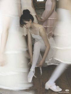 a group of women in white dresses standing next to each other on a wooden floor