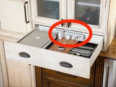 an open drawer in the middle of a kitchen counter with wires and plugs attached to it