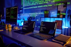 three laptop computers sitting on top of a desk