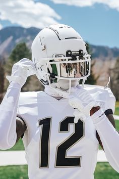 a football player is holding his helmet up