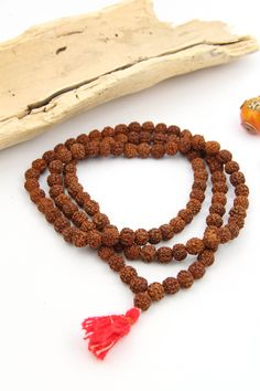 These meditation necklace is strung from Rudraksha seeds. Hailing from India, Rudraksha seeds are traditionally used as prayer beads in Hinduism and Buddhism. They are the seeds of the Rudraksha tree, and legend has it that when Lord Shiva awoke from a long meditation, he shed a tear; from this tear grew the Rudraksha tree.This is an authentic prayer bead necklace, complete with a guru bead and 108 beads; 108 is a significant number for various reasons, but it is believed that one must overcome Traditional Mala With Gemstone Beads For Healing, Holistic Necklaces With 8mm Beads For Festivals, Spiritual Polished Beads For Puja, Spiritual Mala With 8mm Beads For Rituals, Spiritual Healing Mala For Festivals, Healing Spiritual Mala For Festivals, Festival Spiritual Hand-knotted Mala, Festival Mala With Polished Round Beads, Festival Mala With Polished Beads