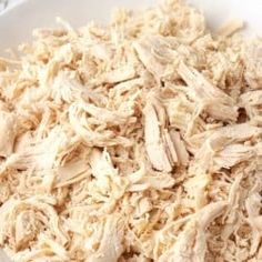 shredded chicken in a white bowl on a table