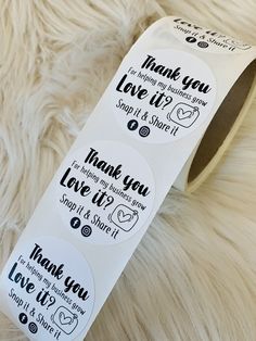 a roll of thank you stickers sitting on top of a furry surface