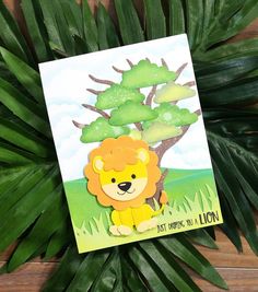 a card with a lion on it sitting in front of a leafy green plant