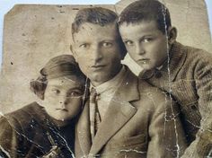 an old black and white photo of two men and a young boy with their arms around each other