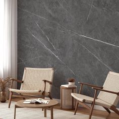 two chairs sitting next to each other in front of a wall with grey marble on it