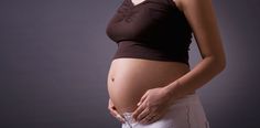 a pregnant woman is holding her stomach