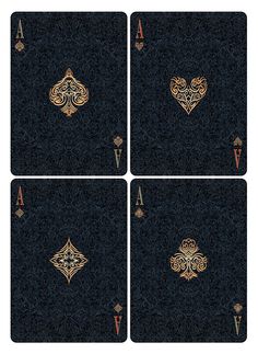 four playing cards with gold designs on black paper and blue fabric, all in the same pattern