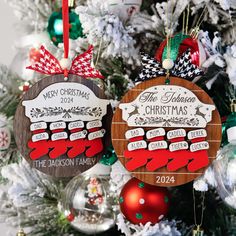 two wooden christmas ornaments hanging from a tree in front of a decorated christmas ornament