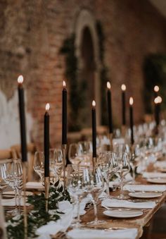 a long table is set with place settings and candles