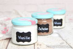 three jars with labels on them sitting on a table