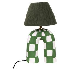 a green and white checkered lamp sitting on top of a table