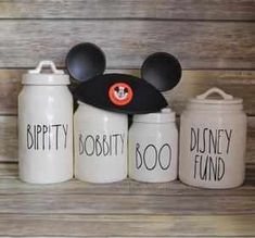 three mickey mouse canisters with disney's ears on them, one is black and the other white