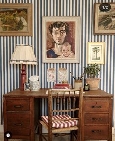 a desk with a chair, lamp and pictures on the wall