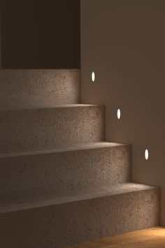 some lights that are on the side of stairs