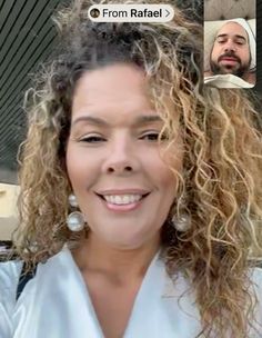 a woman with long curly hair smiling at the camera